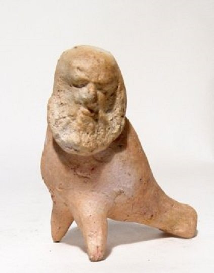 An interesting Greek pottery whistle: An interesting Greek pottery whistle, c. 4th - 3rd Century BC, with bald and bearded male 'philosopher' type head, and two legs balanced by the mouth piece. H: 3 3/8 in (8.6 cm). Repaired break and li