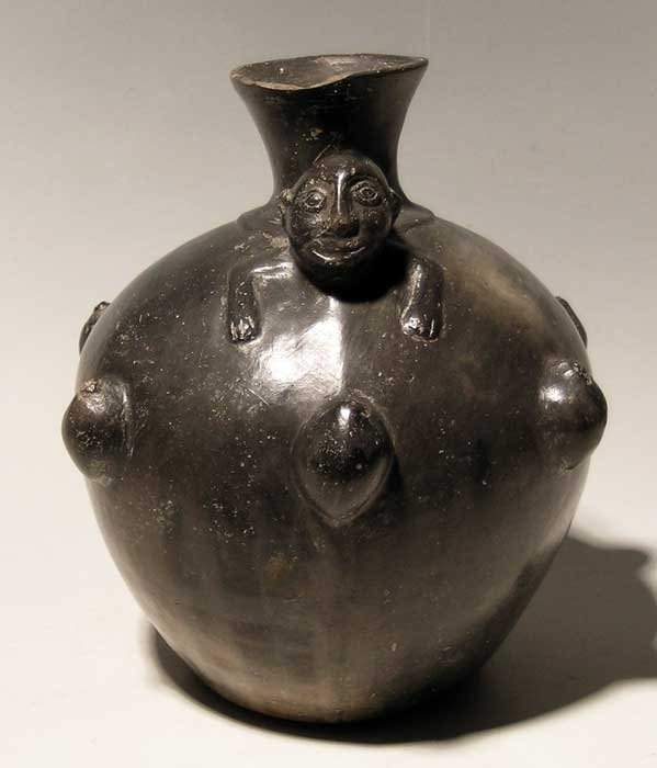A fine Inca vessel from Peru: A fine Inca vessel from Peru, ca. 1300 - 1500 AD. This extensively decorated bottle is 7 in (17.8cm) high and features a nicely detailed monkey draped over the top. The chamber is surrounded by fruit,
