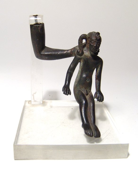 An Egyptian bronze young Harpokrates: An Egyptian bronze young Harpokrates, Late Period, c. 664 - 332 BC, being held by a hand around the shoulders. The young god is beautifully depicted wearing characteristic side-lock and uraeus, his fe