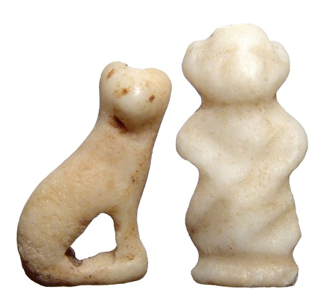 A pair of Egyptian bone amulets: A pair of Egyptian bone amulets, Late Period, c. 64 - 30 BC, the first is in the form of the god Pataikos with his hands on his belly, (H: 2.6 cm), the second is of the goddess Bastet in feline form, 