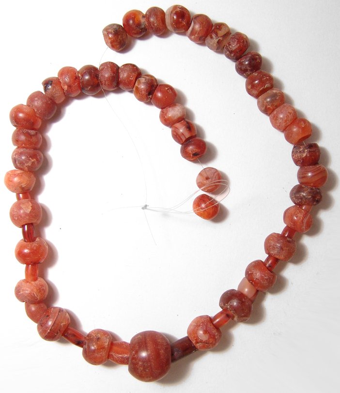 A beautiful strand of carnelian beads, Holy Land: A beautiful strand of carnelian beads, Holy Land, c. 1st Millennium BC, consisting of rounded beads tubular beads with tapered ends, graduating slightly with the largest serving as a pendant. Length a
