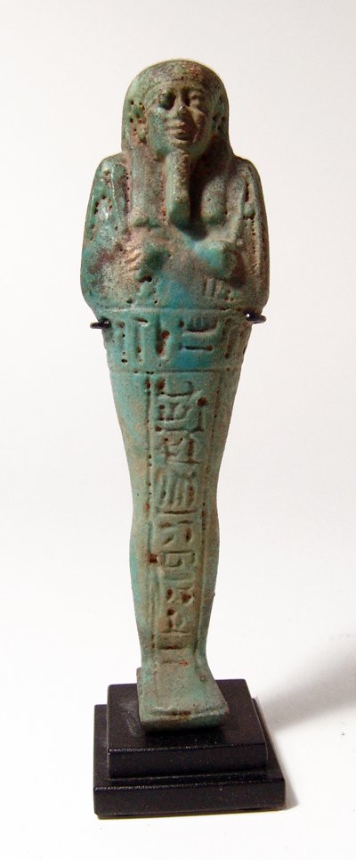 A nice Egyptian blue-green faience ushabti: A nice Egyptian blue-green faience ushabti, Late Period, c. 664 - 30 BC, mummiform and standing on an integral base, wearing tripartite wig and false beard, arms folded across chest, hands holding a p
