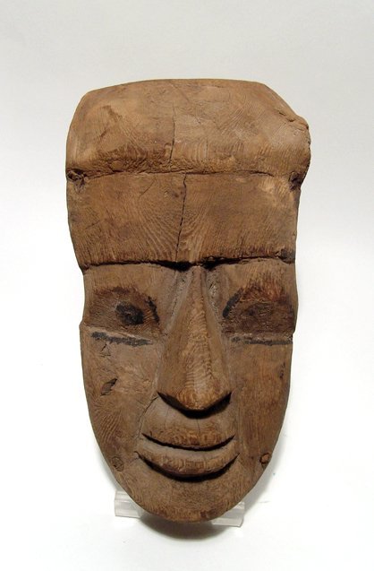 An Egyptian wood funerary mask: An Egyptian wood funerary mask, Late Period, c. 664 - 343 BC, with painted eyes and four wooden dowels. H: 11 1/3 in (28.7cm). Ex North Carolina Private Collection.