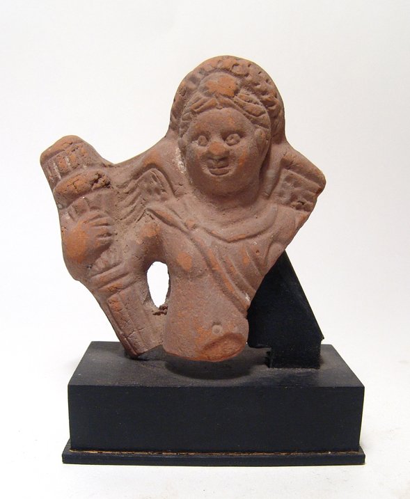 Egyptian terracotta winged Eros: An Egyptian terracotta winged Eros, Ptolemaic, c. 3rd - 1st Century BC, depicted nude wearing a diadem, chlamys over left shoulder, ornate torch clutched in his left hand. H: 3 3/5 in (9.2cm). Light d