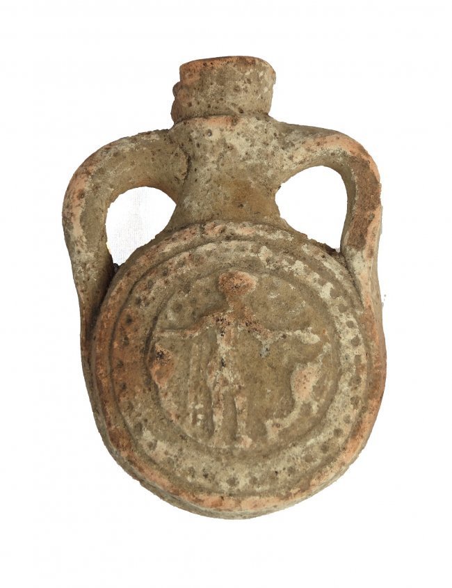A terracotta souvenir pilgrim flask: A terracotta souvenir pilgrim flask, Coptic Egypt, c. AD 480 - 650, depicting Saint Menas on either side, flanked by camels, his arms outstretched in blessing. Above each arm is a quincunx, representi