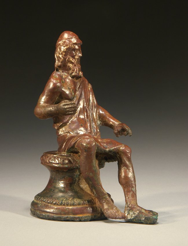 Roman bronze figure of bearded Hephaistos: An outstanding Roman bronze figure of bearded Hephaistos, 1st - 3rd Century AD, the god of the forge, his chiton over one shoulder and wearing a Phrygian cap. He sits on an elaborate round altar and h