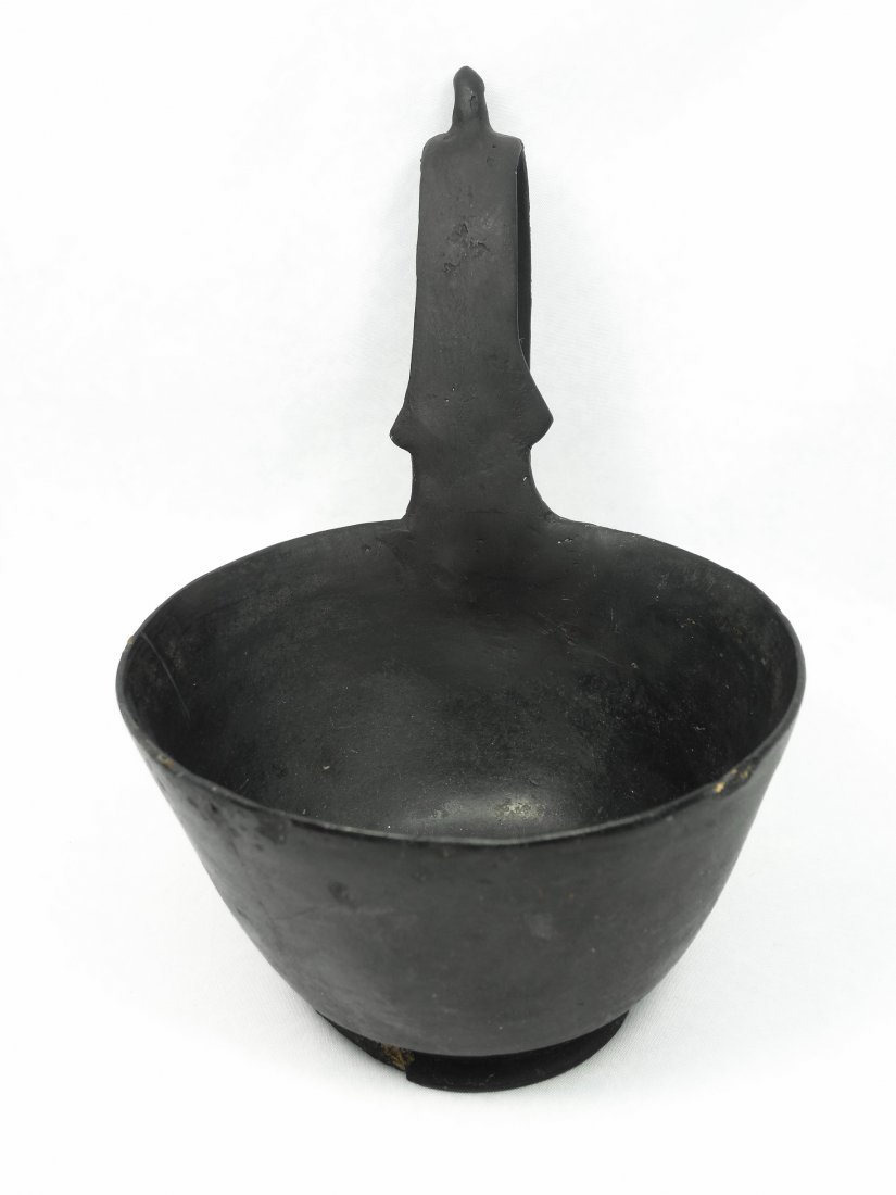 An Etruscan Bucchero kyathos: An Etruscan Bucchero kyathos, c. 560 - 540 BC, with a completely restored handle. Only the bowl remains original. The bowl sits on a flared ring foot. The tall handle with a nipple crest at the top, H