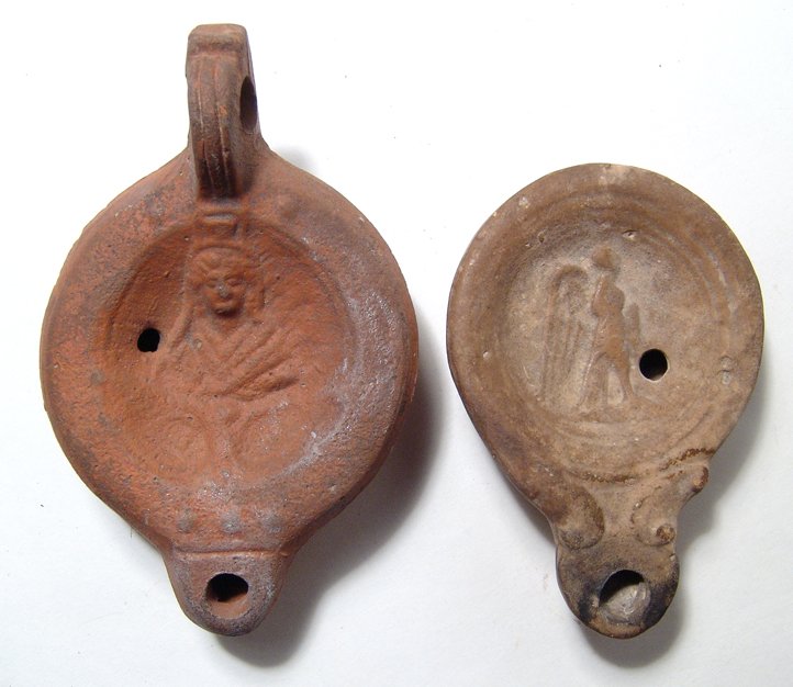 A pair of A Roman ceramic lamps: A pair of A Roman ceramic lamps. The first is a red-ware terracotta lamp with Kybele, 2nd – 3rd Century AD, mold made, with sharp carination and flat shoulder. Central concave discus featuring the d