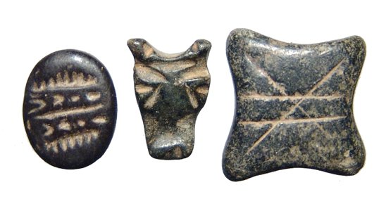 3 steatite amulets from Northern Syria: A lot of 3 steatite amulets from Northern Syria, c. 3rd Millennium BC, the first is a scaraboid type seal with geometric decoration on base and drilled lengthwise for suspension. 1.5 x 1.1 cm; the sec