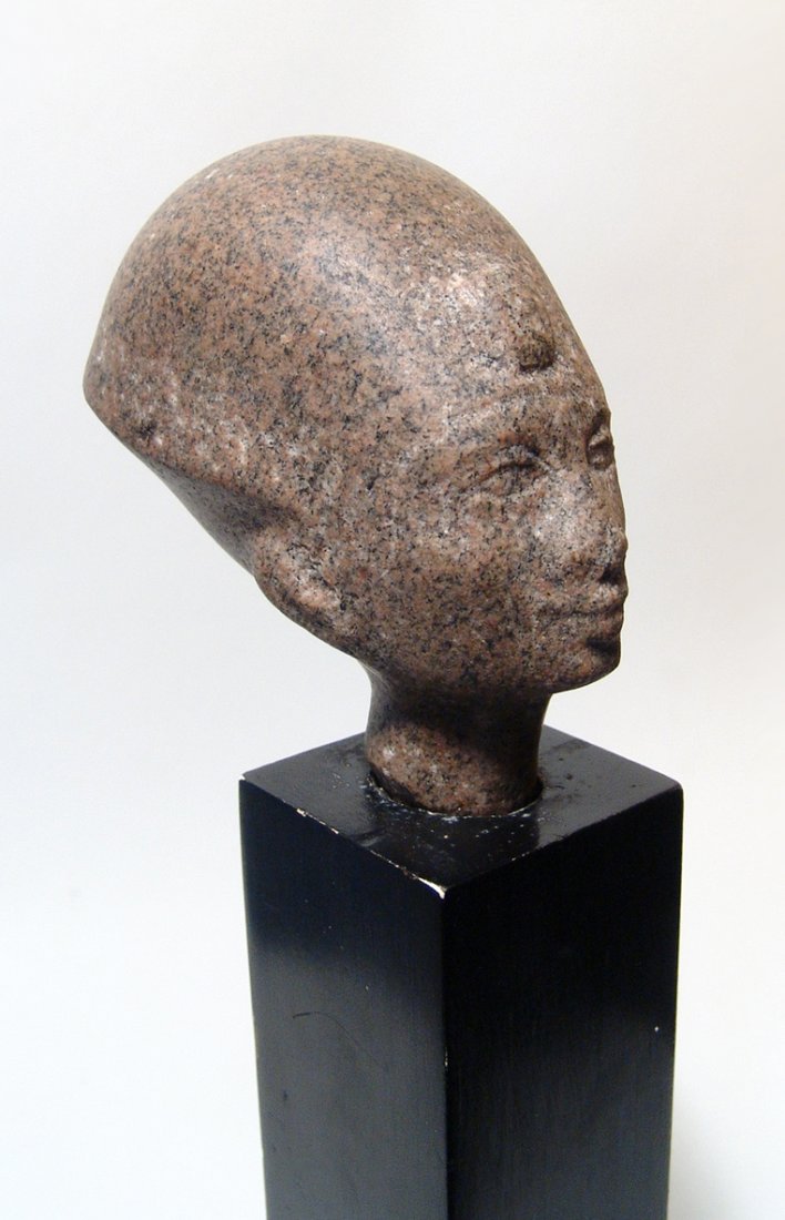 A rare Egyptian Aswan granite head of a pharaoh: A rare Egyptian Aswan granite head of a pharaoh, New Kingdom, c. 1570 - 1075 BC, wearing a war crown with uraeus, the features pleasantly carved, the styled calling to mind portraits of the royal fami
