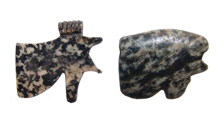 Pair of Egyptian granite Eye of Horus amulets: A pair of Egyptian granite Eye of Horus amulets, c. 1200 - 332 BC, in two different styles, the less detailed of the two holed lengthwise for suspension. Largest L: 2/3 in (1.7cm). Ex Boston Museum of