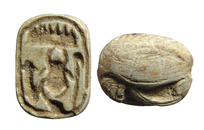 An Egyptian oval plaque and a Scaraboid: An Egyptian oval plaque and a Scaraboid, New Kingdom, c. 1570 – 1075 BC, the scaraboid with a body in the form a\of an Eye of Horus, the base with four symmetric cobras, 13 x 10mm, the oval plaque w