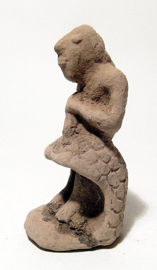 A nice Mesopotamian terracotta kilted figure: A nice Mesopotamian terracotta kilted figure, c. 3rd Millennium BC, a man, depicted standing with hands clutching an uncertain object against his chest, his features are clear and his wears a wrapped