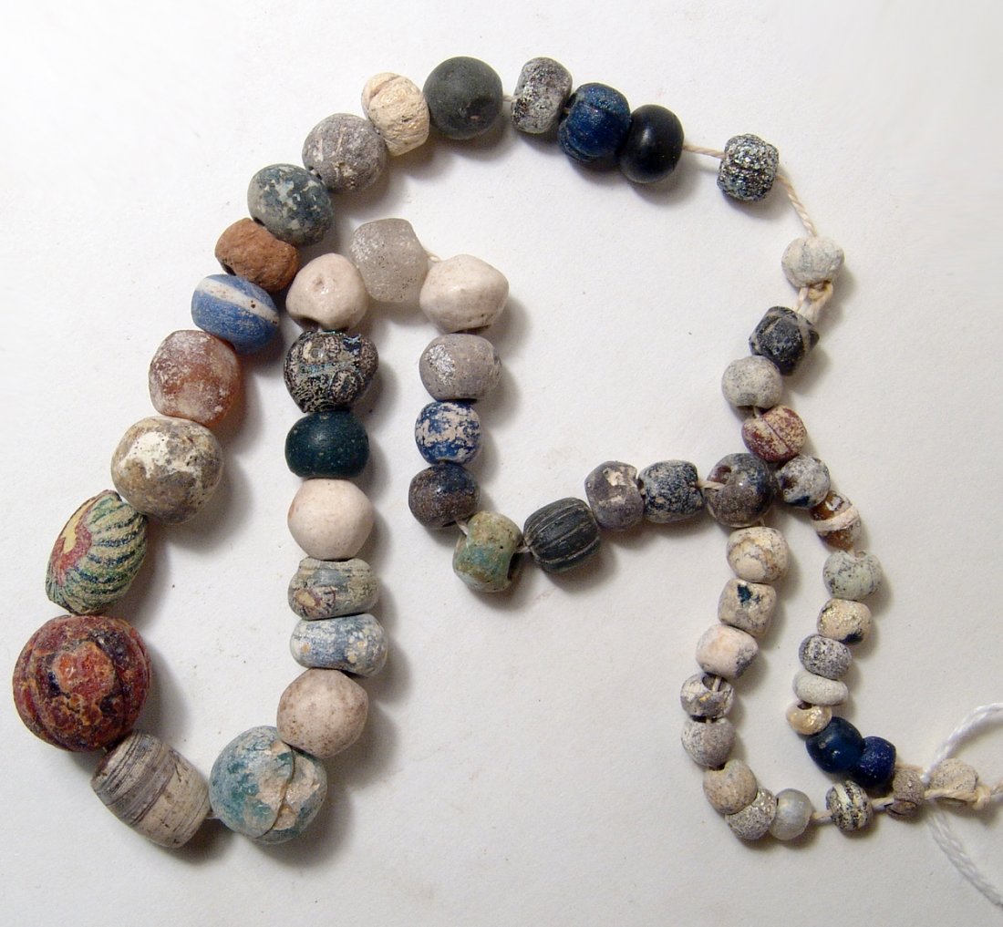 A Near Eastern/Holy Land necklace: A Near Eastern/Holy Land necklace consisting of stone and faience beads, mostly 1st to 5th Century AD. L: 9 ¼ in (23.5cm). Ex New York private collection.
