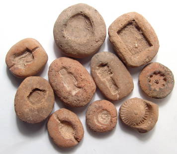 A lot of 10 New Kingdom terracotta amulet molds: A lot of 10 New Kingdom terracotta amulet molds, New Kingdom, c. 1570 - 1075 BC. Lot includes a mold for a Wedjat, or 'Eye of Horus', a flower, a fruit-shaped collar element, a Djed Pillar amulet of