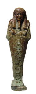 An Egyptian green faience ushabti: An Egyptian green faience ushabti, Late Period, c. 64 - 332 BC, mummiform and standing on integral base, wearing tripartite wig and false beard, arms folded across chest, hands holding hoes, basket