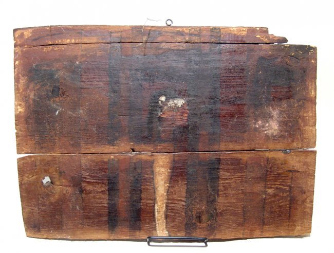 Egyptian wooden panel from a sarcophagus: Large Egyptian wooden panel from a sarcophagus with stripes of black and red paint, and what appears to be the profile of either a mummy or god, perhaps Ptah, H: 17 2/5 in (44.3cm), W: 12 1/5 in (31cm