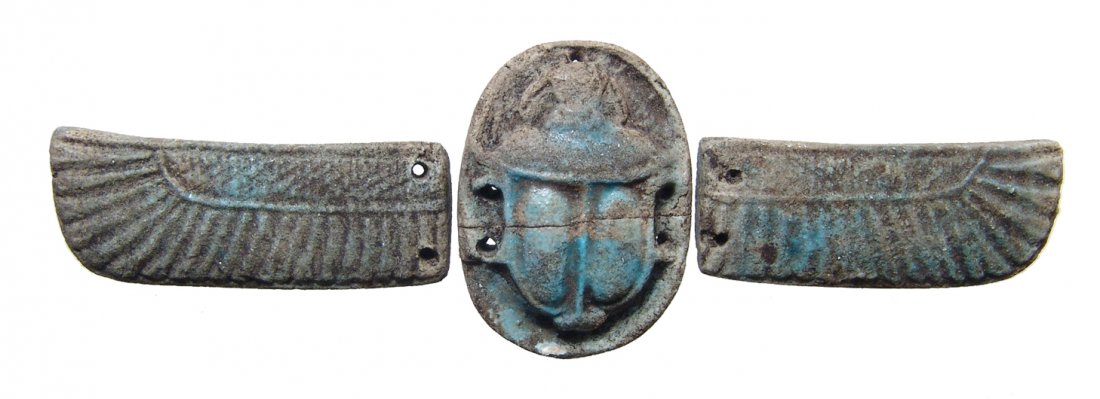 A lovely Egyptian faience winged scarab: A lovely Egyptian faience winged scarab, Late Period, c. 664 – 30 BC, part of a pectoral for a mummy, with excellent style and detail with remains of light blue glaze. W: 5 ¾ in (14.6 CM). Light de