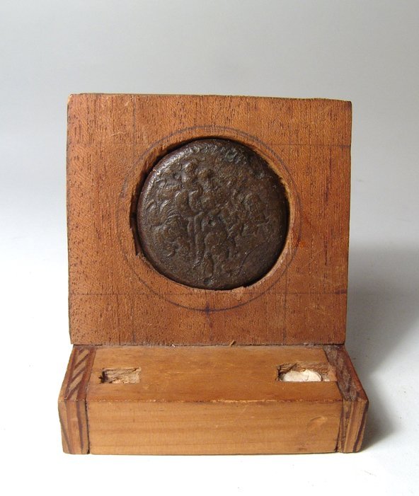 Egyptian bronze coin in antique wood mount, Ptolemaic: An Egyptian bronze coin in antique wood mount, Ptolemaic, 3rd Century BC, the obverse featuring the head of Zeus-Ammon facing to rt., the reverse with an eagle. D: 40mm. Ex West Sussex, UK private col