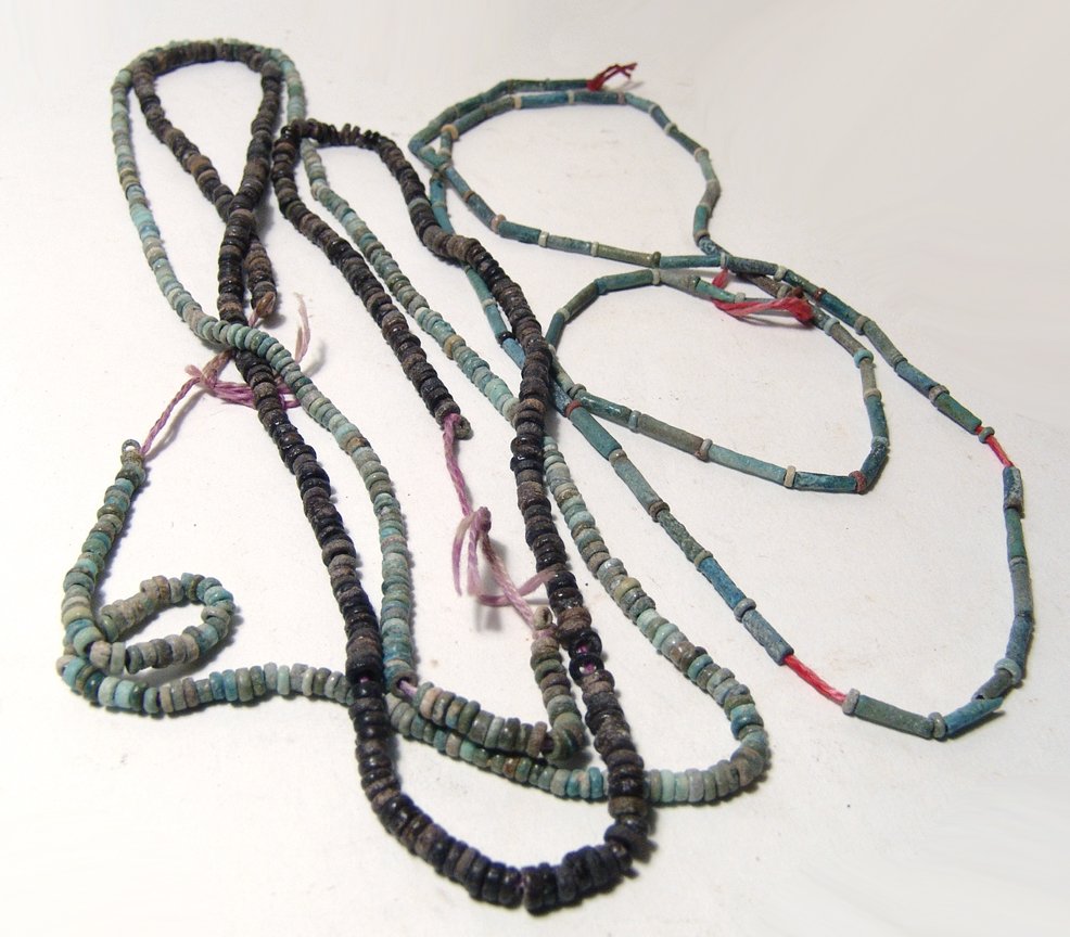 A lot of strands of Egyptian faience beads: A lot of strands of Egyptian faience beads, Late Period, c. 664 – 30 BC, the first a very long strand of disk beads in shades of light green and grey to black, L: 57 in (144.4 cm), the second a stra