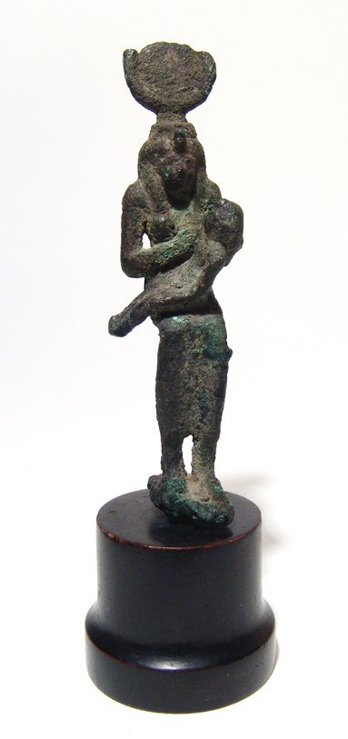 Egyptian bronze figure of seated Isis, Late Period: An Egyptian bronze figure of seated Isis, Late Period, c. 64 - 332 BC, suckling the infant Horus who sits on her lap. The goddess wears a tight-fitting gown and headdress consisting of a solar disk an