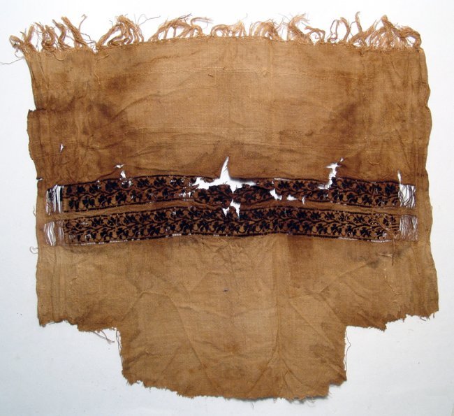 Coptic shawl fragment with bands of floral decoration: A Coptic shawl fragment with bands of floral decoration, Egypt, 4th – 5th Century AD, linen and wool, the edge of the panel with original fringing. The deep brown geometrized floral decoration contr