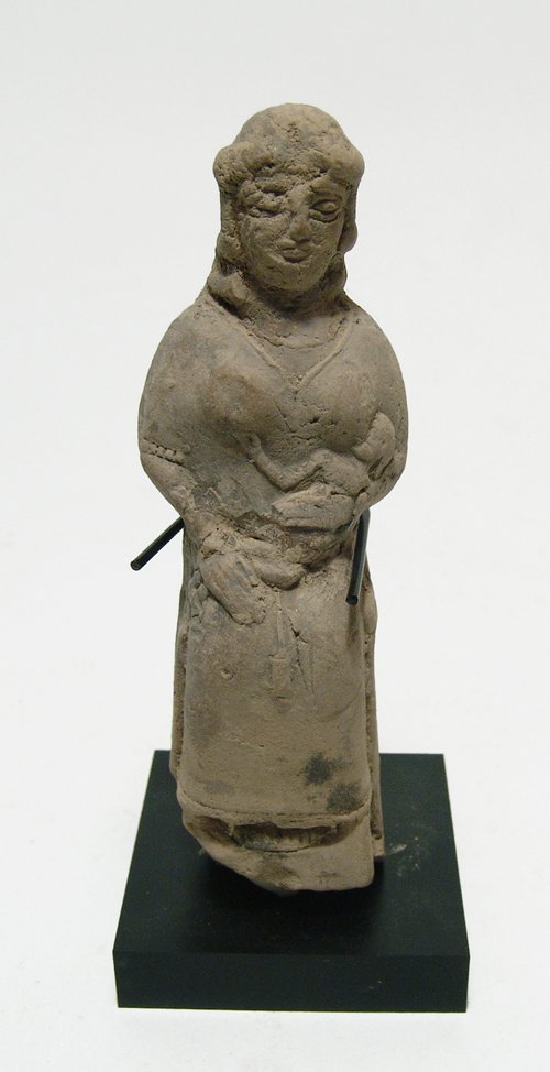 An Old Babylonian terracotta seated woman: An Old Babylonian terracotta seated woman, c. 1900 - 1750 BC, the goddess sits on her throne suckling an infant in the manner of the goddess Isis who suckles the young god Horus, who she cradles with