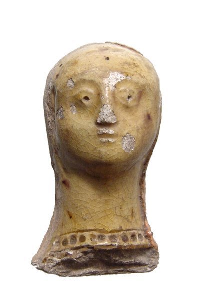 A Byzantine female head with yellow glaze: A Byzantine female head with yellow glaze, c. 8th - 10th Century AD, with attractive features, traces of a headdress in another substance remain and she wears a beaded or pearl necklace. An interestin