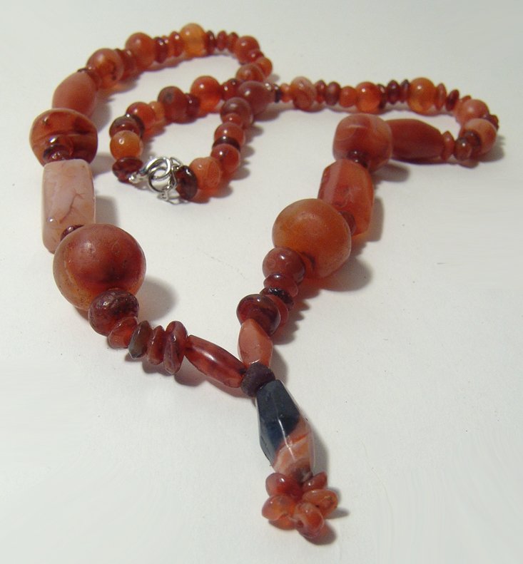 A beautiful strand of carnelian beads, Holy Land: A beautiful strand of carnelian beads, Holy Land, c. 1st Millennium BC, in a variety of shapes and sizes, each hand cut and drilled, many retaining their original polish. Length roughly 35 in (88.9 cm