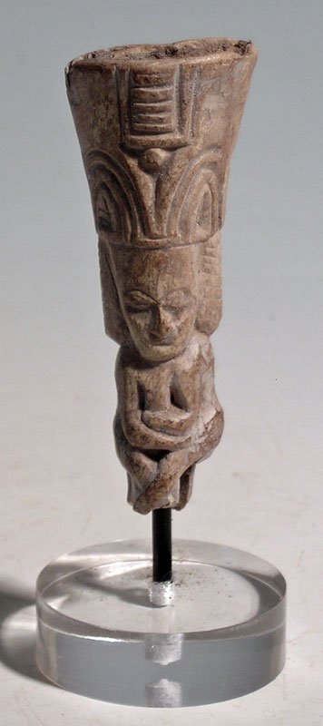 A rare Tumaco shamanic bone idol from Colombia: A rare Tumaco shamanic bone idol from Colombia, ca. 300 BC - 400 AD. This beautifully carved figure is 2-3/4 in high and depicts a shaman wearing an elaborate headdress. He is posed seated, with arms 
