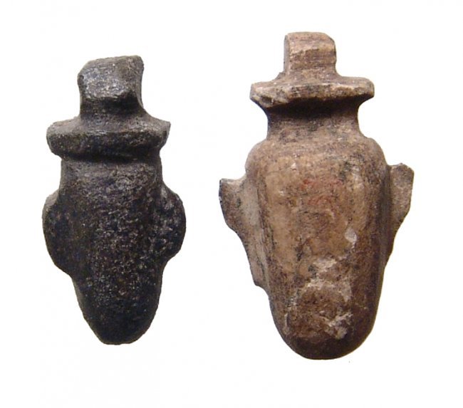 A pair of Egyptian stone heart or 'ib' amulets: A pair of Egyptian stone heart or 'ib' amulets. Both amulets date from the Late Period, c. 64 - 332 BC, one in a speckled brown steatite and the other in a black stone. Both are well carved and the bl
