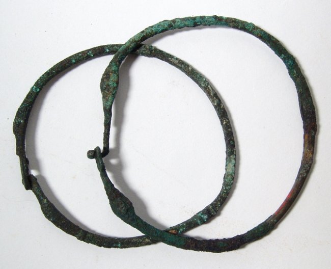 Pair of bronze armlets or chokers, Western Asia: A pair of bronze armlets or chokers, Western Asia, 1st millennium BC, both composed of thick wire with a simple clasp fastener, one with decorative bands of tightly wrapped thin wire. The large with r