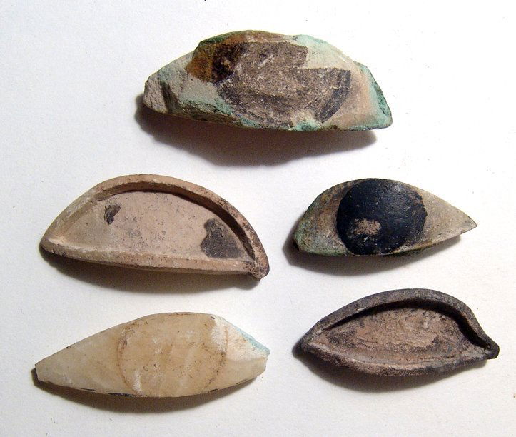 A lot of 5 Egyptian stone eye inlays for statuary: A lot of 5 Egyptian stone eye inlays for statuary, Late Period, c. 664 - 30 BC, three of alabaster with added pigment, the other two in limestone and are the frames the eyes themselves originally sat