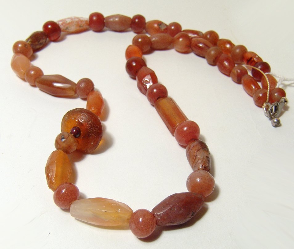 A necklace comprised of mixed carnelian beads: A necklace comprised of mixed carnelian beads, c. 1st Millennium BC/AD, with differing shapes including rounded examples and some with faceted sides, several with nice desert varnish. L: 21 1/3 in (54