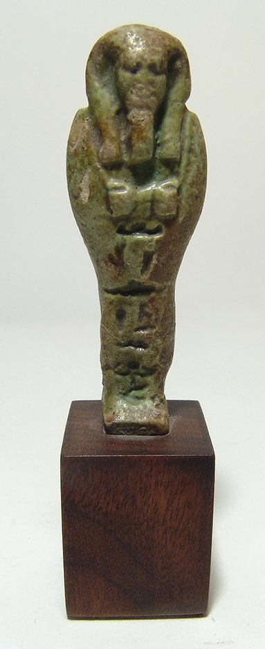 Egyptian green glazed ushabti, Late Period: An attractive Egyptian green glazed ushabti, Late Period, c. 664 - 332 BC, mummiform, wearing tripartite wig and false beard, arms crossed at chest, a hoe in each hand, hieroglyphic inscription down f