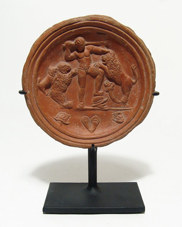 Stunning Roman red-ware tondo depicting fighting scene: A stunning Roman red-ware tondo depicting a fighting scene, North Africa, c. 4th – 5th Century AD. The fantastic scene depicts a man fighting of a lion and bear with an axe, while a dog also attacks