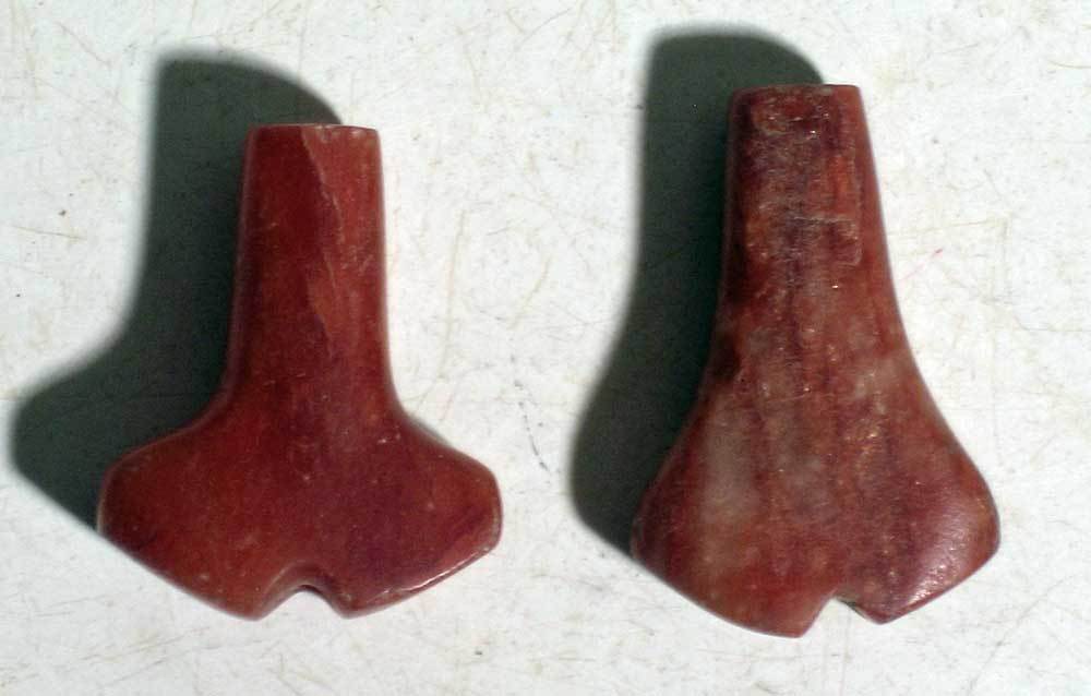 A pair of rare Tairona 'Anchor' pendants: A pair of rare Tairona 'Anchor' pendants from Colombia, ca. 1000 - 1500 AD. They are 1-1/4 in and 1-1/8 in long and are made from fine red carnelian. Both are perforated lengthwise and are highly poli