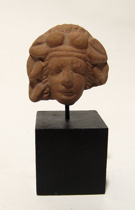 Greek terracotta female head wearing a large headdress (1 of 3)