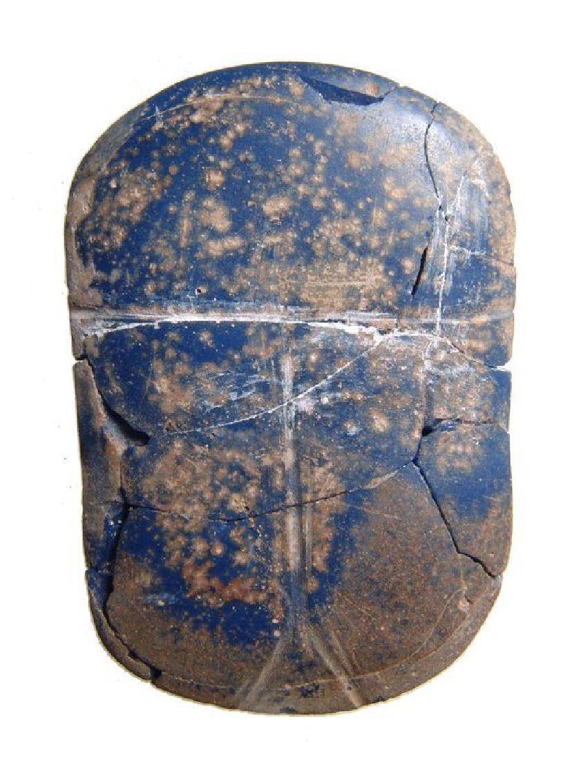 An Egyptian blue glass scarab, Ptolemaic: An Egyptian blue glass scarab, Ptolemaic, c.3rd - 1st Century BC, the central portion of a winged scarab pectoral for a mummy or inlay, the body simplified with incised divisions of the shell and wing