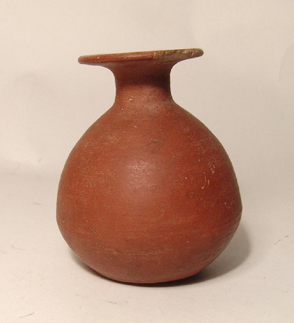 Egyptian red-ware aryballos, Late Period: An Egyptian red-ware aryballos, Late Period, c. 664 – 30 BC, the piriform body with flattened bottom, shot neck and widely flared rim. Nice deep red wet burnished surfaces with light deposits. H: 4 
