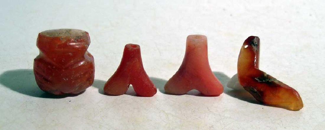 Group of four Tairona pendants from Colombia: A group of four Tairona pendants from Colombia, ca. 1000 – 1500 AD. All are carved from red carnelian, the largest is 1-1/8 in long. The group consists of a rotund figure, two anchor types and a tra