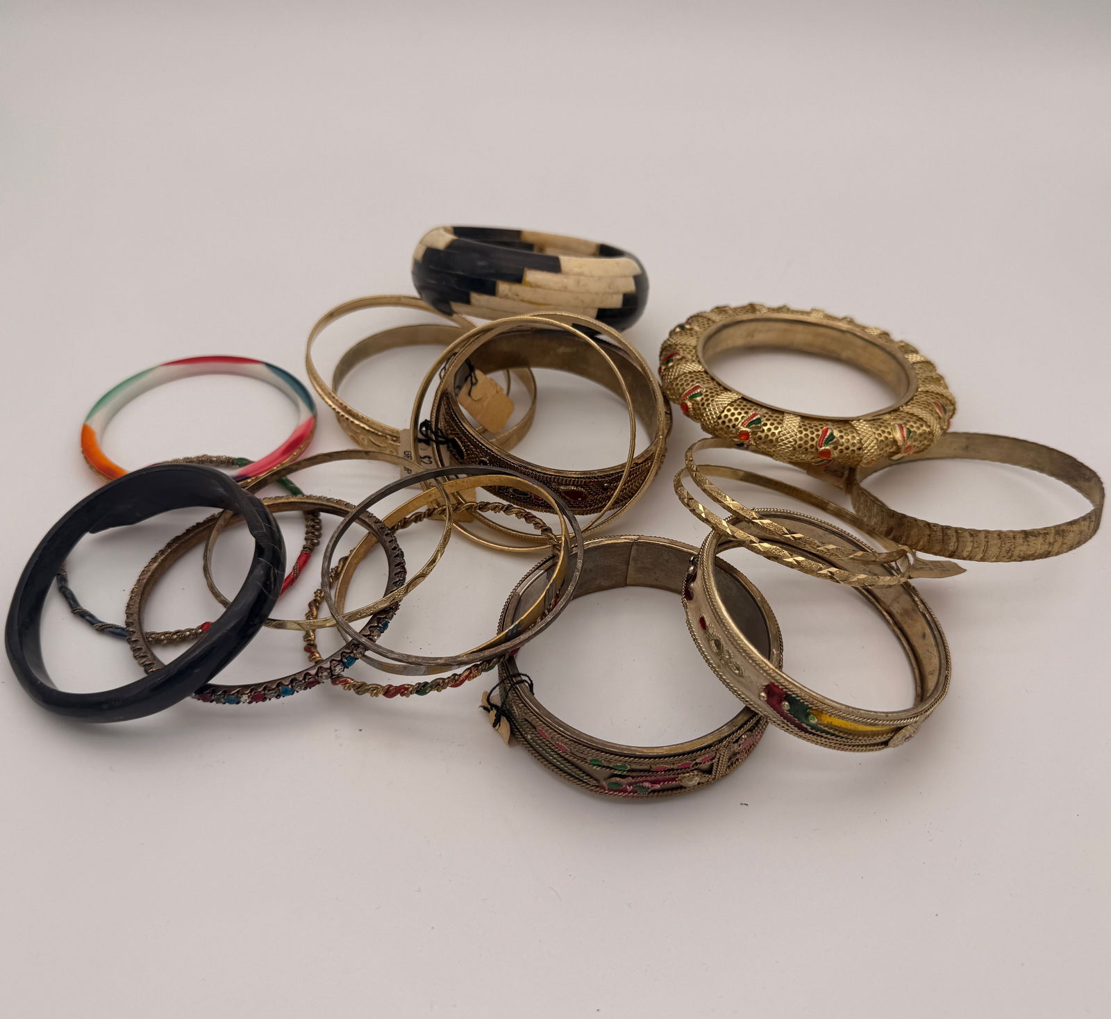 Lot of Vintage Costume Jewelry Bangles, 15+ Pieces: Group of over fifteen assorted vintage costume jewelry bangles in metal, resin, and enamel finishes. Includes decorative etched, beaded, and rhinestone-accented designs, mid-to-late 20th century.