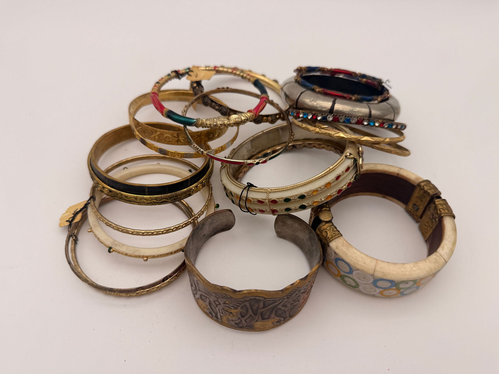 Lot of Vintage Costume Jewelry Bangles, 15+ Pieces: Group of over fifteen assorted vintage costume jewelry bangles in metal, resin, and enamel finishes. Includes decorative etched, beaded, and rhinestone-accented designs, mid-to-late 20th century.