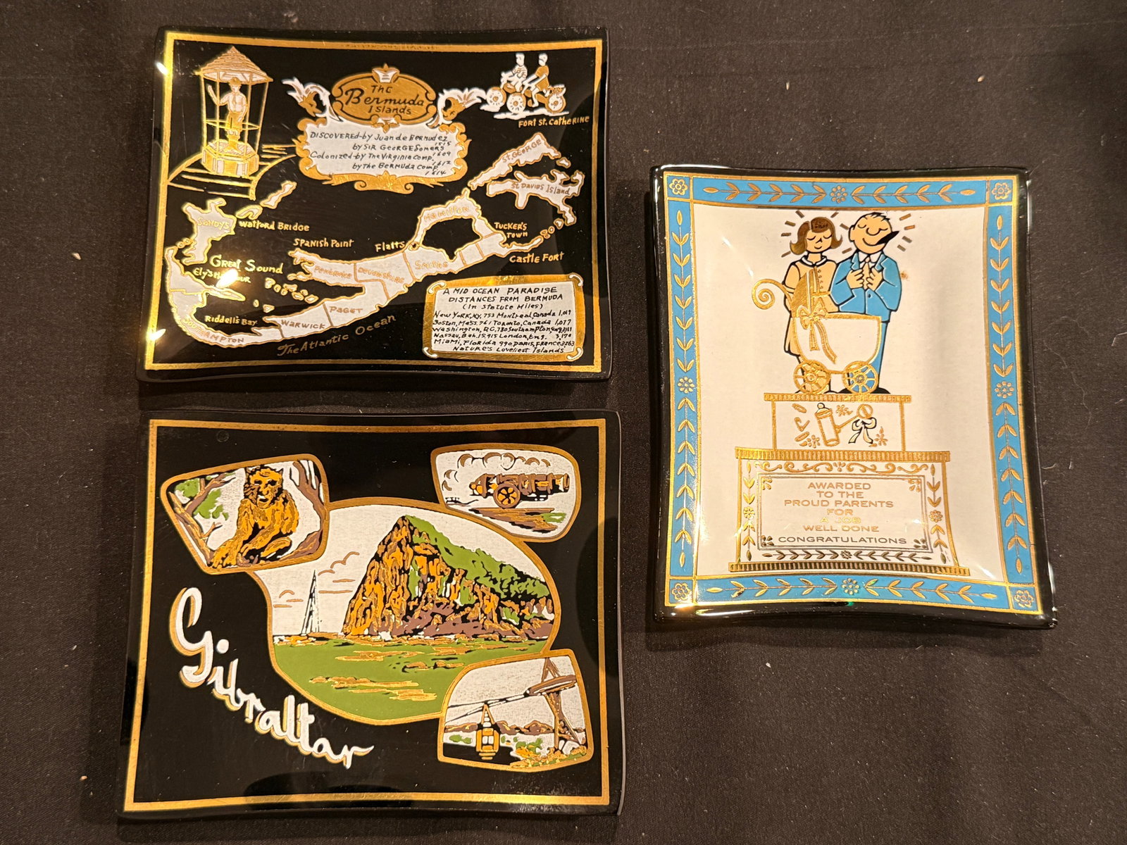 Three Vintage Souvenir Gilt Glass Catch-Alls: Decorative souvenir glass catch-all trays featuring Bermuda, Gibraltar, and novelty award motifs.