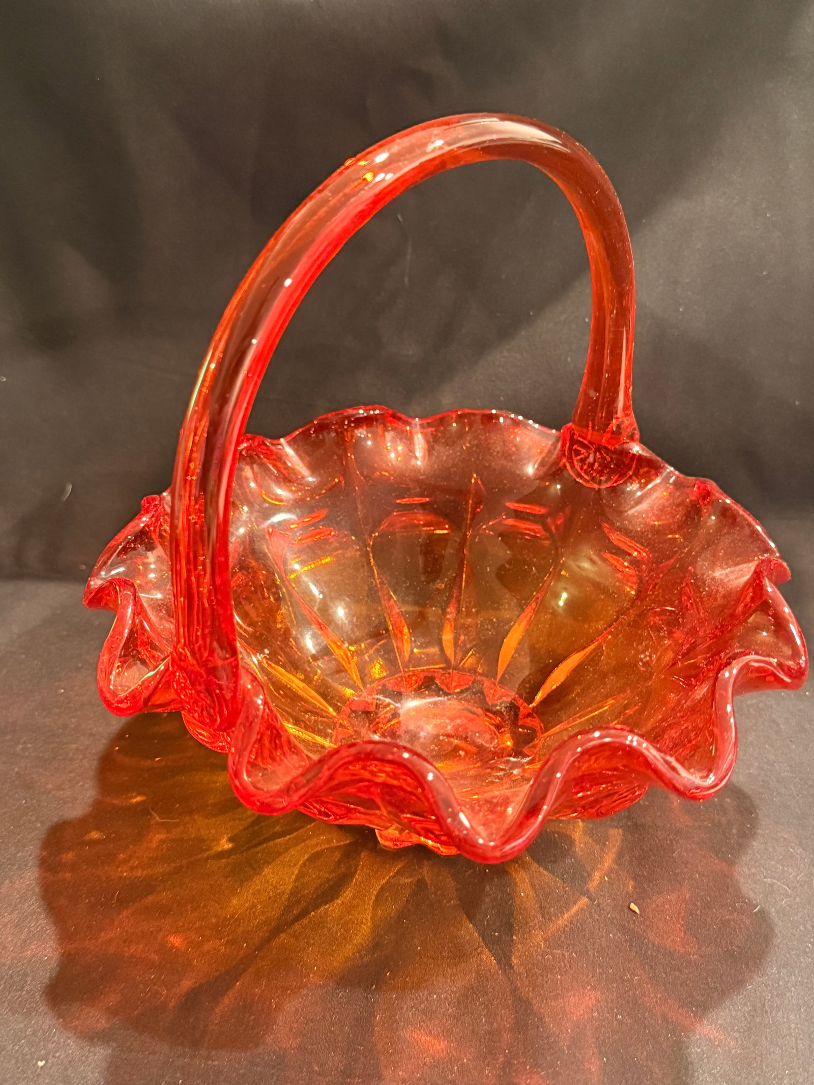 Orange Pressed Glass Basket with Handle: Orange pressed glass basket with ruffled rim, applied handle, and decorative molded interior. 7.75" x 7.5" x 7.25"