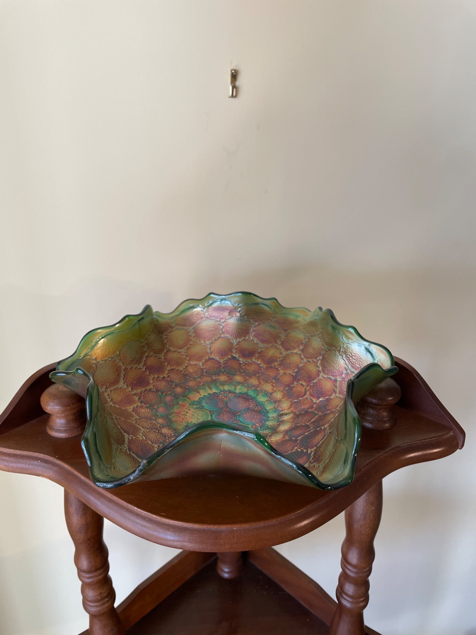 Iridescent Green Carnival Glass Bowl with Ruffled Edge: This item is an iridescent green carnival glass bowl with a ruffled edge and an intricate honeycomb texture on its interior. The diameter measures approximately 9 inches. The base has a round foot