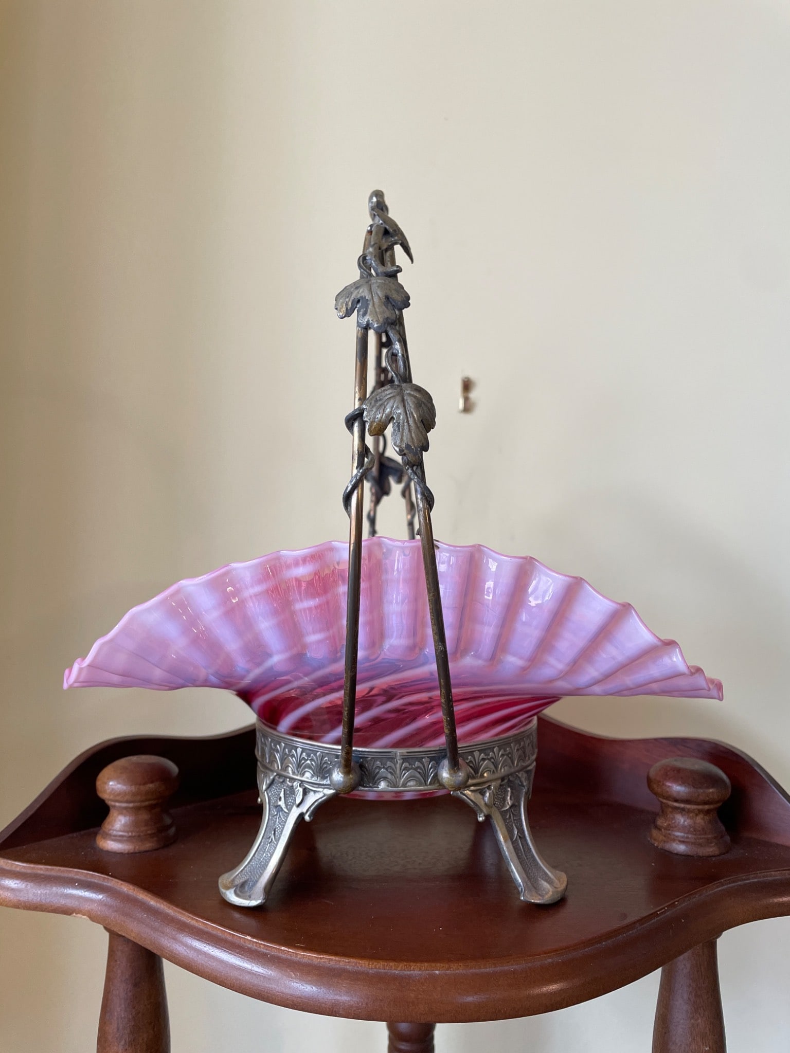 Pink Glass Bride's Basket with Hard White Metal Frame, Model No. 827: This lot features a pink glass bride's basket with a swirled ribbed design and ruffled edges. The basket is supported by a decorative metal base marked "Hard White Metal" and model number "827." The