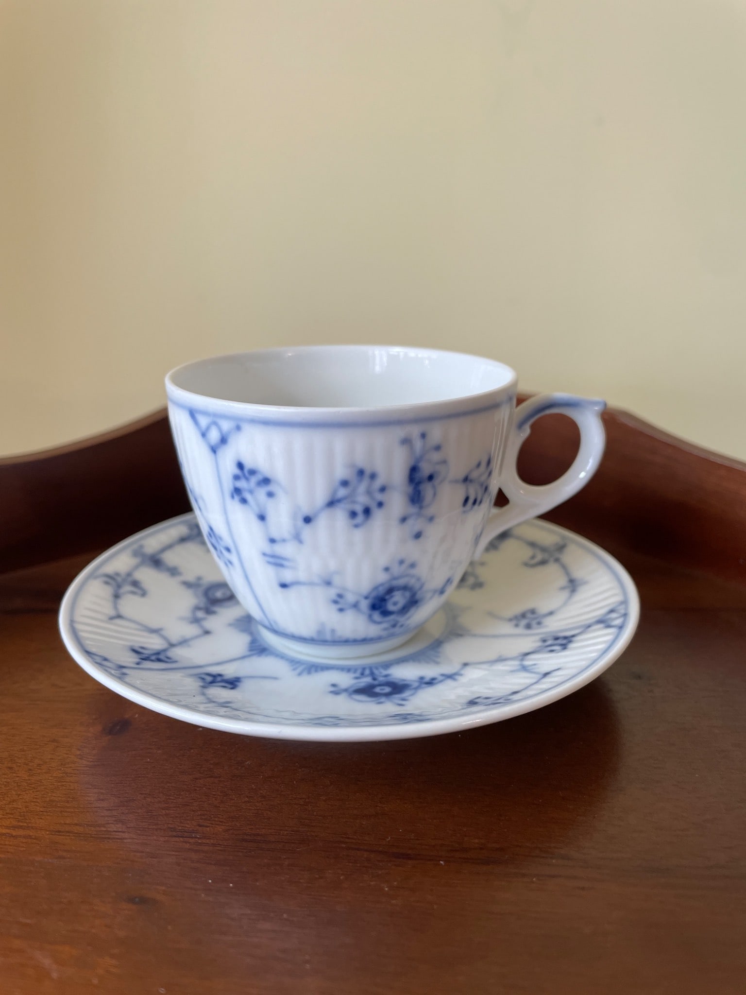Royal Copenhagen Blue Fluted Plain Tea Cup and Saucer, Model 1018/1212: This is a Royal Copenhagen Blue Fluted Plain tea cup and saucer. The pattern features a classic blue and white floral design with a ribbed texture. The underside of the items is marked with Royal Cope