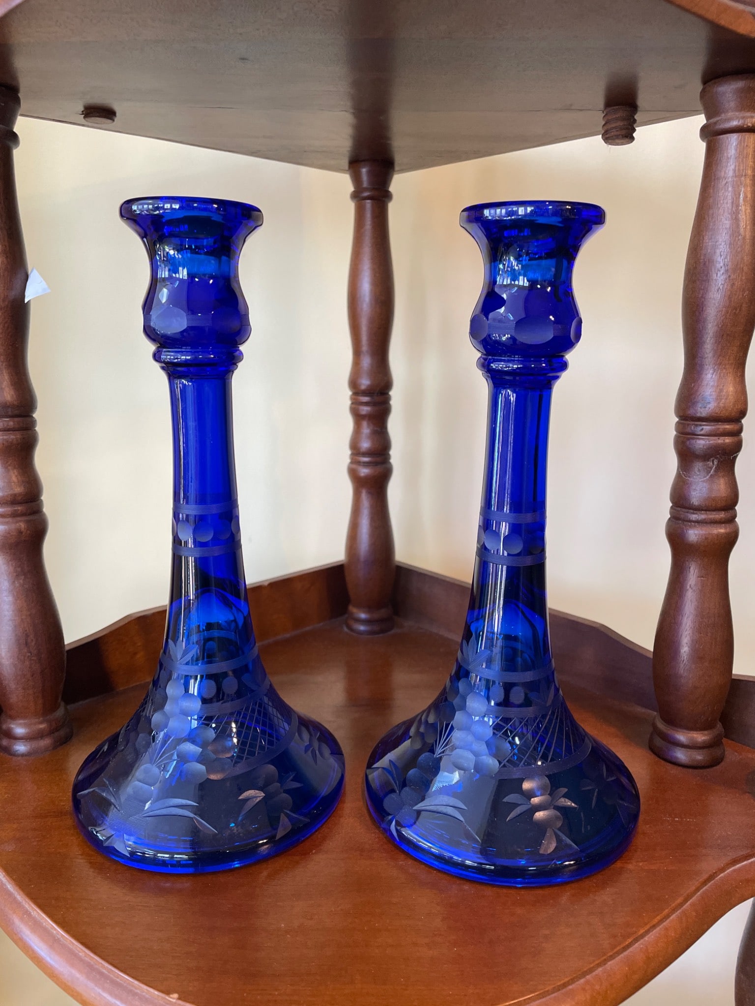 Cobalt Blue Glass Candlestick with Etched Floral Design, Approximately 11 Inches Tall: This is a cobalt blue glass candlestick featuring an etched floral and lattice design around the base. The candlestick stands approximately 11 inches high and has a stable, flared base. The design