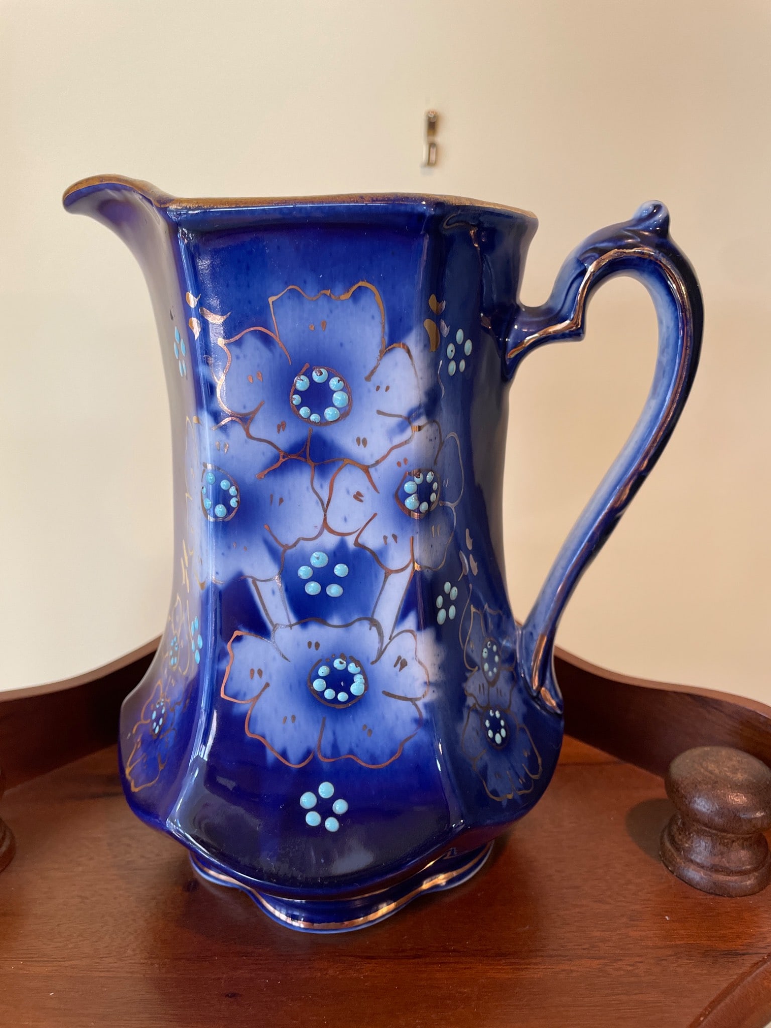 Blue Porcelain Pitcher with Floral Design, Model No. 4054: This is a blue porcelain pitcher with hand-painted floral motifs in white and gold accents. The model number '4054' is marked on the underside of the base. The pitcher measures approximately 8.5